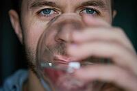 Man drinks water, Close-up shot of bearded man drinking fresh clean water from glass, Quenching thirst, Lifestyle healthcare concept [IBR124497494]