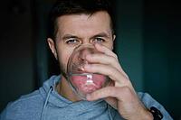 Man drinks water, Close-up shot of bearded man drinking fresh clean water from glass, Quenching thirst, Lifestyle healthcare concept [IBR124497497]
