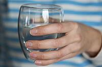 Woman drinks water, Close-up shot of man holding glass of fresh water, Quenching thirst, Lifestyle healthcare concept [IBR124497498]