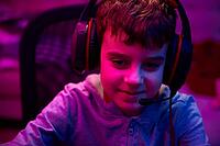 Portrait of boy playing computer video game in dark room, workplace for cybersport gaming, children gaming addiction [IBR124497506]
