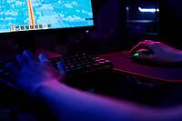 Professional gamer play computer video game in dark room, use neon colored rgb mechanical keyboard, place for cybersport gaming [IBR124497515]