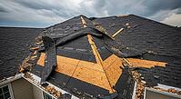 House roof with shingles torn off showing damage from a storm under a cloudy sky, construction materials failure concept, AI generated [IBR124550798]