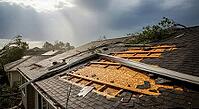 Damaged roof with sunlight breaking through clouds after a storm, surrounded by trees, construction materials failure concept, AI generated [IBR124550803]