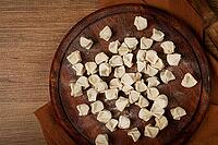 Traditional Turkish dumplings, raw, on a cutting board, top view, no people [IBR124552174]