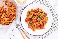 Rigatoni pasta with spicy sausage, and rich tomato sauce served, on a white plate, homemade [IBR124552176]