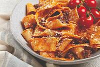 Pappardelle pasta with bolognese sauce, topped with parmesan cheese and cherry branch, homemade, no people [IBR124552192]