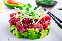 Fresh tuna tartare with avocado served on a marble table with soy sauce and seaweed salad [IBR124552193]