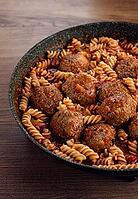 Minced meat meatballs, in tomato sauce, with fusilli pasta, in a cast-iron pan, homemade, no people [IBR124552194]