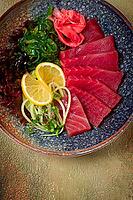 Tuna sashimi with daikon and wakame salad, pickled ginger, in a bowl [IBR124552198]