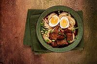Asian noodles in broth, with beef and egg, top view, close-up, no people [IBR124552204]