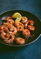 Fried tiger prawns, jumbo, in garlic sauce, in butter, with herbs, in a frying pan, homemade, no people [IBR124552221]