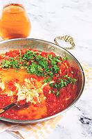 Traditional Turkish dish, scrambled eggs with tomatoes, Menemen, with herbs, in a frying pan, close-up, no people [IBR124552254]
