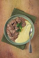 Liver beef stroganoff with mashed potatoes, table setting in green tones, homemade [IBR124552257]