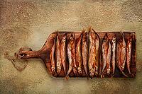 Cold smoked capelin, on a wooden chopping board, no people [IBR124585334]