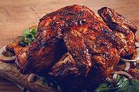 Whole fried chicken, with spices, grilled chicken, on a chopping board, top view, homemade, no people [IBR124585339]