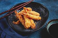 Shrimp in tempura, deep fried, on a black plate, with soy sauce, close-up, top view, no people [IBR124585352]