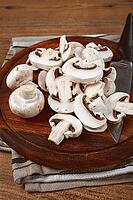 Fresh mushrooms, chopped, in a wooden bowl, whole, top view, no people [IBR124585361]