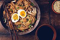 Buckwheat noodles, soba, with shimeji mushrooms, boiled egg, green onion, sesame seeds, homemade, no people [IBR124585367]
