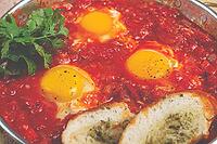 Shakshuka, breakfast, fried eggs in tomato sauce, with spices and herbs, homemade, no people [IBR124585377]