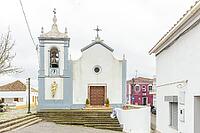 View of Igreja Paroquial de São Marcos da Serra, the parish church of São Marcos da Serra village in the Algarve interior of Portugal, surrounded by traditional white houses, rolling hills, and rural countryside [IBR124586579]