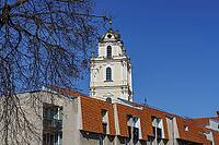Historic church tower above modern residential buildings with branched trees, Vilnius, Lithuania, Baltic States [IBR124586580]