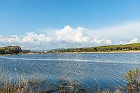 Beautiful natural landscape in Quarteira, Algarve, Portugal featuring a calm lagoon, and lush green vegetation under a clear blue sky. Peaceful outdoor scene ideal for travel, nature, and countryside themes. Keywords [IBR124586606]