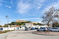 Sunny view of Castro Marim village with its historic hilltop castle, traditional white houses, and parked cars under a blue sky in the Algarve region of southern Portugal [IBR124586636]