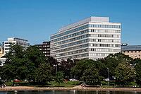 Helsinki, Finland - June 21, 2015 - Modern office building with park and people relaxing on a sunny day [IBR124626835]