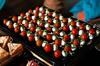 A vibrant arrangement of caprese skewers featuring juicy tomatoes, mini mozzarella balls, and fresh pesto. ideal for parties, these appetizers add color and flavor to any gathering [IBR124626859]