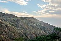 Scenic mountain range landscape under cloudy sky at sunset [IBR124626860]