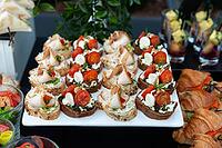 A beautifully arranged platter of gourmet canapés featuring fresh ingredients like cherry tomatoes, cheese, and assorted toppings. ideal for upscale gatherings or parties [IBR124626868]