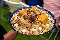 A vibrant middle eastern dish featuring roasted poultry, seasoned rice, nuts, and boiled eggs. this hearty meal is traditionally served during festive gatherings and cultural celebrations [IBR124626870]