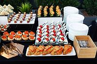 A meticulously arranged buffet showcasing a variety of appetizers including croissants, skewered tomatoes, bite-sized sandwiches, and more. ideal for events, parties, or gatherings [IBR124626883]