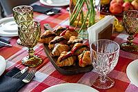 A well-set brunch table features croissants filled with fresh ingredients on a wooden board. crystal glassware and vibrant tablecloth add elegance and style to the setting [IBR124626891]