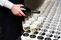 A person elegantly pours champagne into multiple crystal-clear glasses, creating an inviting atmosphere for a special event or celebration. each glass is meticulously lined up, promising a toast to memorable moments [IBR124626895]