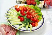A colorful assortment of fresh vegetables, including cucumbers, tomatoes, and lettuce, arranged on a platter. perfect for parties or healthy eating occasions [IBR124626898]