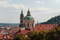 Prague, Czech - August 22, 2013 - St. nicholas church in prague: baroque architecture with red rooftops and cityscape view [IBR124626909]