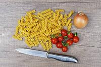 Onions (Allium cepa) with cocktail tomatoes (Solanum lycopersicum) and fusilli pasta, Kempen, North Rhine-Westphalia, Germany [IBR124629094]