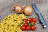 Onions (Allium cepa) with cocktail tomatoes (Solanum lycopersicum) and fusilli pasta, Kempen, North Rhine-Westphalia, Germany [IBR124629098]