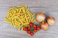 Onions (Allium cepa) with cocktail tomatoes (Solanum lycopersicum) and fusilli pasta, Kempen, North Rhine-Westphalia, Germany [IBR124629102]