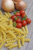 Onions (Allium cepa) with cocktail tomatoes (Solanum lycopersicum) and fusilli pasta, Kempen, North Rhine-Westphalia, Germany [IBR124629105]