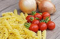 Onions (Allium cepa) with cocktail tomatoes (Solanum lycopersicum) and fusilli pasta, Kempen, North Rhine-Westphalia, Germany [IBR124629106]