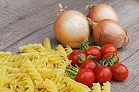 Onions (Allium cepa) with cocktail tomatoes (Solanum lycopersicum) and fusilli pasta, Kempen, North Rhine-Westphalia, Germany [IBR124629108]