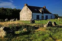 This atmospheric picture shows the famous stone rows of Carnac in Brittany. Numerous Neolithic menhirs rise from the grass and lead the eye to a characteristic stone house. The low sun bathes the scene in golden light and accentuates the rough granite tex [IBR124629130]