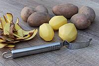 Peeled and unpeeled Laura potatoes with potato peeler, Kempen, North Rhine-Westphalia, Germany [IBR124629557]