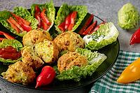 A plate of baked balls, pizza balls surrounded by lettuce leaves, pepper strips and dip [IBR124636273]