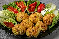 A plate of baked balls, pizza balls surrounded by lettuce leaves, pepper strips and dip [IBR124636274]