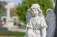Sculpture of a little angel on a tomb in cemetery. Graz, Austria [IBR124636285]