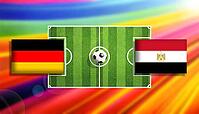 Germany and Egypt flags face off across a central soccer ball on a vivid green pitch with radiant rainbow light streaks, portraying an intense international football clash, created using generative AI tools, AI generated [IBR124642059]