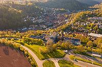 Aerial view of a village in a hilly, green landscape, roads and fields visible in sunshine, Calw District Office, Calw District, Germany [IBR124642836]